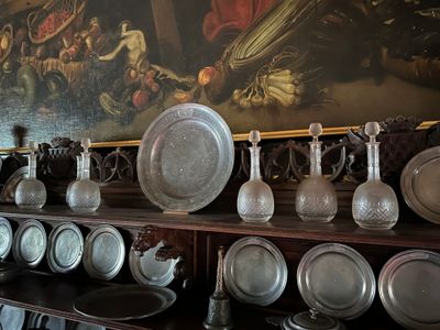 many plates and vases on a shelf in a room