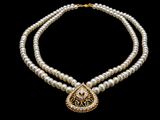 a white pearl necklace with a gold pendant on a black background