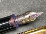a close up of a pen and a fountain pen on a table
