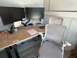 un bureau avec un ordinateur et une chaise devant un tableau blanc