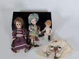 three dolls that are sitting next to each other on a table