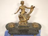 une statue représentant une femme tenant un oiseau, posée sur une table