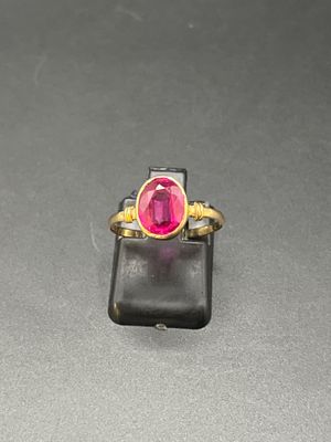 une photo d'une bague en pierre rose posée sur un téléphone portable