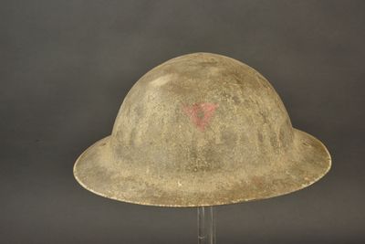 un vieux casque sur lequel est peint un cœur rouge sur le côté