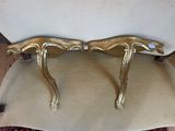 pair of gold leaf shaped chairs on a beige cushion on a wooden floor