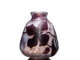 un vase orné d'une fleur, posé sur une surface blanche