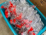 many plastic fish in a blue container on the floor