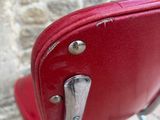 a red chair with a metal frame and a red seat