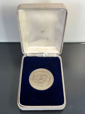a close up of a silver medal in a case on a table