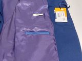 purple and blue jacket sitting on top of a table next to a cell phone