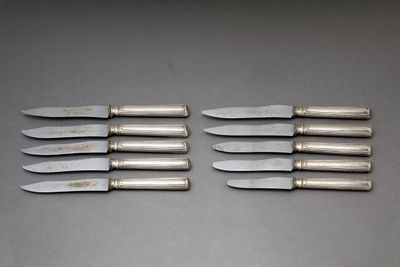 six couteaux sont alignés sur une table