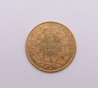 gros plan d'une pièce d'or sur une surface blanche