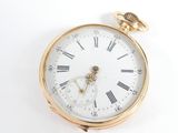 a gold pocket watch with roman numerals on the face
