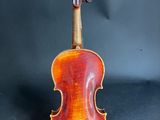 an old violin sitting on top of a black surface