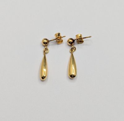 une paire de boucles d'oreilles en or sur fond blanc