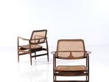 une paire de chaises longues avec des assises en rotin et une table à plateau en verre