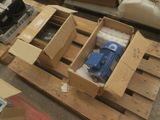 une boîte contenant une pompe bleue, posée sur une palette