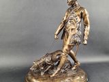 bronze statue of a man with a dog on a leash
