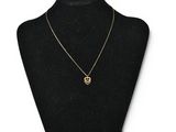 a black mannequin with a gold necklace on it