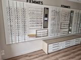 many rows of glasses on the wall in the store