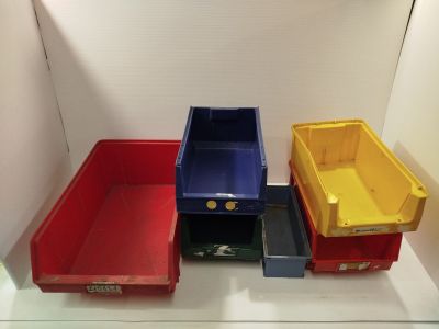 three different colored bins sitting on a shelf in a room