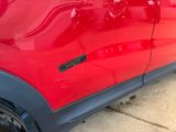 a close up of a red car with a sticker on it