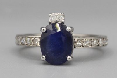 un gros plan d'une bague en saphir et diamants posée sur une table