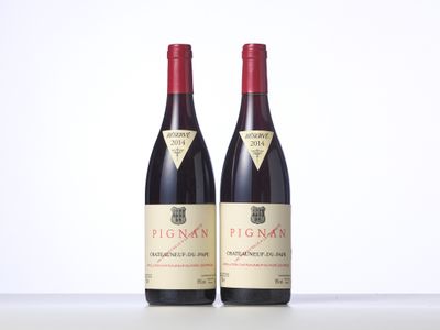 two bottles of red wine sitting on top of a table