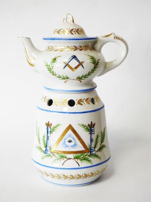 une théière blanche ornée d'un motif bleu et or