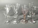 six wine glasses sitting next to each other on a table