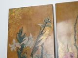 two paintings of flowers on the wall in the room