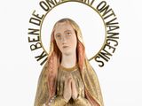 statue of the virgin mary holding a cross with a quote above it