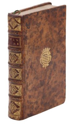 un vieux livre avec un emblème en or sur la couverture