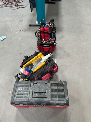 une boîte à outils et des outils posés par terre dans un garage