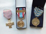 three medals are sitting in a black box on a white surface
