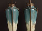 two vases sitting on a table with a black background