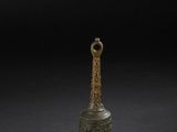 une cloche en bronze sur fond noir, avec une ombre
