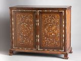 an antique carved wooden cabinet with two doors and two drawers