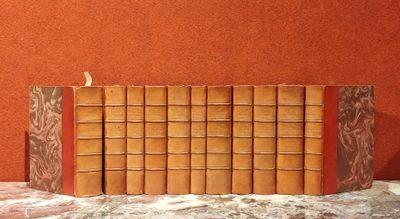 une pile de livres posée sur une table, avec un mur rouge en arrière-plan