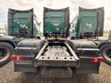 three green semi trucks that are parked in a lot