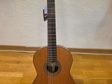 an acoustic guitar on a stand on a hard wood floor