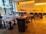 des tables et des chaises dans un restaurant, avec une grande baie vitrée en arrière-plan
