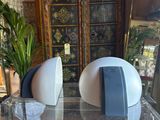 two speakers sitting on a clear table in a living room