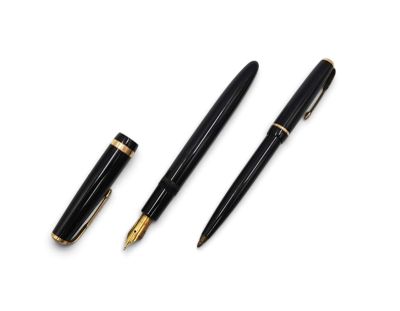 a couple of pens sitting next to each other on top of a white surface