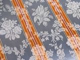 a bed that has a blue and orange striped comforter on it