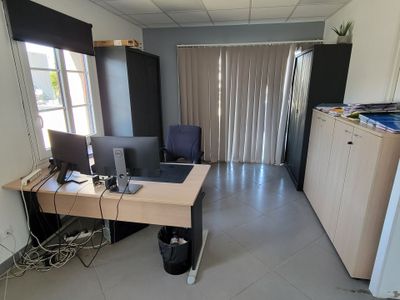 a room with a desk and a refrigerator in it