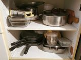 many pots and pans on the shelves in the kitchen