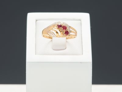 Gros plan sur une bague en or ornée d'une pierre rouge