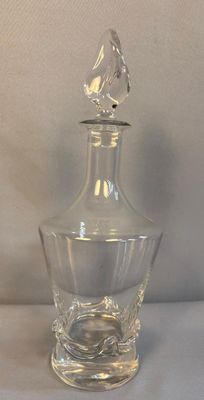 une image représentant une bouteille en verre transparent surmontée d'un oiseau