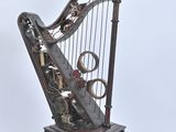 a metal harp that is sitting on a wooden stand